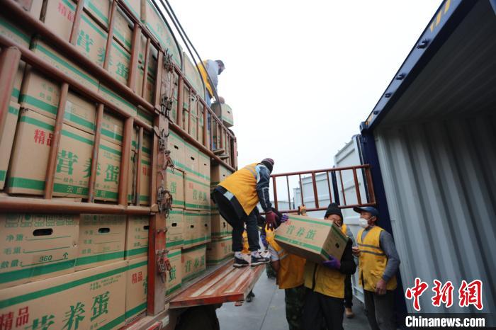 圖為鐵路裝卸作業(yè)人員正在將云南特色農產品裝入集裝箱?！詈?攝