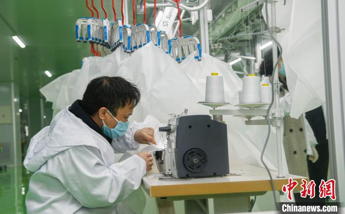 工人生產(chǎn)防護(hù)服，保障抗疫物資供應(yīng)。廣安市委宣傳部供圖