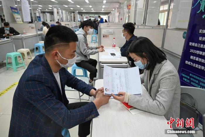 4月14日，招聘者在查看求職者簡(jiǎn)歷。<a target='_blank'  data-cke-saved- >中新社</a>記者 王剛 攝