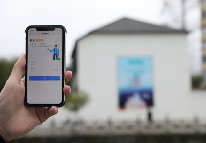 在浙江省杭州市臨安區(qū)天目山鎮(zhèn)，一名居民在“杭州健康碼”海報上掃碼申領(lǐng)個人二維碼。新華社發(fā)