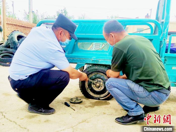 賽旦與民警共同維修三輪摩托車?！∫懒窘?攝
