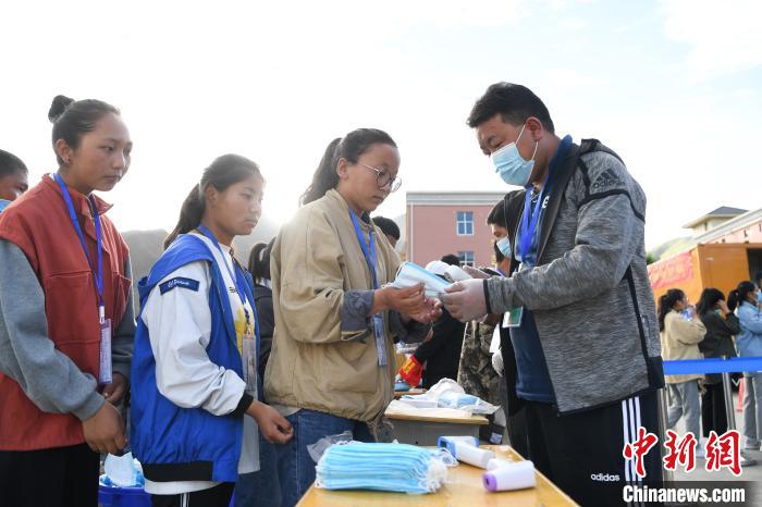 7月7日，考生在拉薩三高考點(diǎn)外領(lǐng)取口罩?！『闻罾?攝