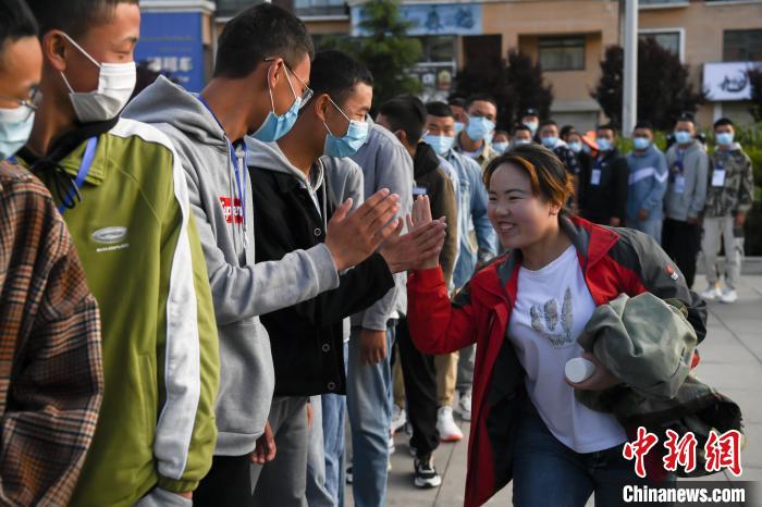 7月7日，拉薩三高考點(diǎn)外，領(lǐng)隊(duì)老師與考生擊掌鼓勁加油?！『闻罾?攝