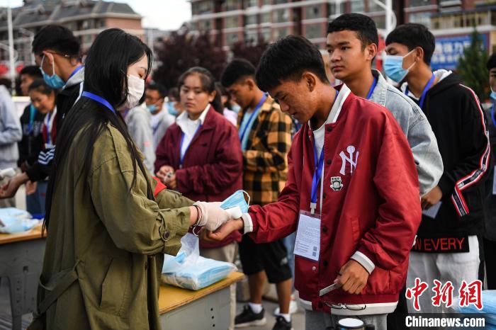 7月7日，考生在拉薩三高考點(diǎn)外測量體溫?！『闻罾?攝