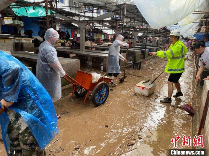 圖為7月26日，暴雨引發(fā)的洪水過境后，重慶萬州區(qū)分水鎮(zhèn)政府干部職工及志愿者清掃淤泥和垃圾?！　≈貞c萬州區(qū)委宣傳部供圖 攝